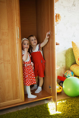 boy and girl playing hide and seek in closet