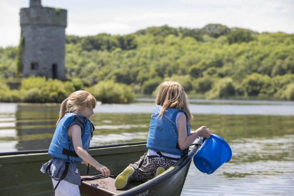 Children enjoying a boat ride on Lough Erne at Crom, County Fermanagh. This 2,000 acre demesne is surrounded by tranquil islands and ancient woodlands.