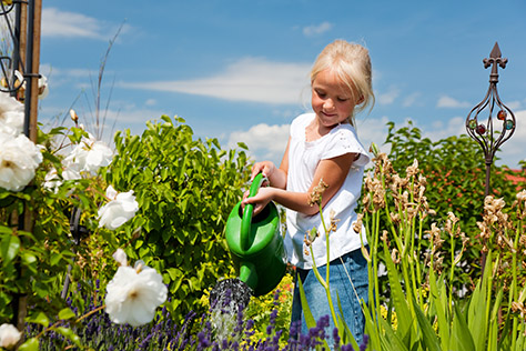 bigstock-little-girl-watering-the-flowe-12193742