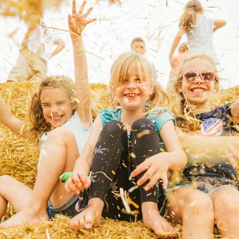 children playing with hay at a family festivals